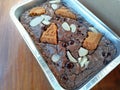 fresh from the oven fudgy brownies with chocochips and almond toppings on the wooden table