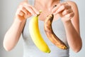 Fresh and overripe bananas on woman hand