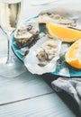 Fresh oysters close-up on blue plate, served table with oysters, lemon and champagne in restaurant Royalty Free Stock Photo