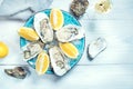 Fresh oysters close-up on blue plate, served table with oysters, lemon and champagne in restaurant Royalty Free Stock Photo