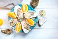 Fresh oysters close-up on blue plate, served table with oysters, lemon and champagne in restaurant. Gourmet food Royalty Free Stock Photo