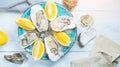 Fresh oysters close-up on blue plate, served table with oysters, lemon and champagne in restaurant. Gourmet food Royalty Free Stock Photo