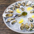 Fresh oysters close-up on a dish, served with oysters, lemon and ice. Healthy seafood. Oyster dinner with champagne in a Royalty Free Stock Photo
