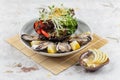 Fresh oysters and Japanese salad served with Sliced and lemon sauce on white stone bowl on makisu meal mat