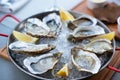 Fresh oysters with lemon`s slices in ice. Restaurant delicacy, beautiful table setting. Saltwater oysters dish. Romantic dinner i Royalty Free Stock Photo