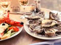 Fresh oysters served on a table in summer restaurant with lemon and lobster garnished with freshly made mayonnaise