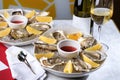 Fresh oysters in a white plate with ice and lemon. Open Oysters and glass of white wine. Tasty Oysters On Ice