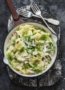 Fresh papardelle with chicken ragout , green peas and fennel in pan on wooden rustic board on dark background, top view
