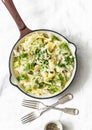 Fresh papardelle with chicken ragout , green peas and fennel in pan on wooden rustic board on light background, top view