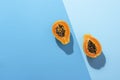Fresh papaya fruit cut in half on blue background. Tropical fruit Royalty Free Stock Photo