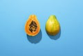 Ripe papaya fruit cut in half on blue background in harsh light Royalty Free Stock Photo