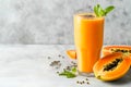 Fresh papaya smoothie topped with chia seeds, mint leaf garnish, copy space. Ripe papaya slices beside a tall glass of exotic Royalty Free Stock Photo