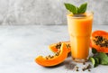 Fresh papaya smoothie topped with chia seeds, mint leaf garnish. Ripe papaya slices beside a tall glass of exotic smoothie. Royalty Free Stock Photo