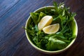 Fresh Parsley and Arugula / Rucola or Rocket Leaves with Lemon in Ceramic Bowl. Royalty Free Stock Photo