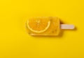 a fresh passion fruit flavor popsicle with slice of orange on a yellow background Royalty Free Stock Photo