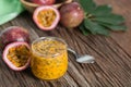 Fresh passion fruit in glass and organic passionfruit on wooden background