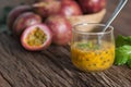 Fresh passion fruit in glass and organic passionfruit on wooden background