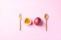 Passion fruit with wooden spoon and fork on pink background Royalty Free Stock Photo