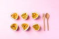 Passion fruit with wooden spoon and fork on pink background Royalty Free Stock Photo