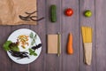 Fresh pasta ingredients in eco paper bags - spaghetti pasta, carrot, basil, tomato and other vegetables, notepad for recipe Royalty Free Stock Photo