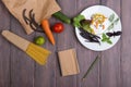 Fresh pasta ingredients in eco paper bags - spaghetti pasta, carrot, basil, tomato and other vegetables, notepad for recipe Royalty Free Stock Photo