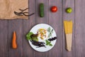 Fresh pasta ingredients in eco paper bags - spaghetti pasta, carrot, basil, tomato and other vegetables on plate Royalty Free Stock Photo