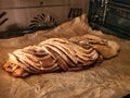 Fresh pastries: curd roll - pigtail with cinnamon in the oven on craft parchment