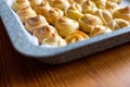 Fresh pastries in a metal baking tray. The corner of the baking tray in small buns, baking in the shape of a rose Royalty Free Stock Photo