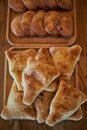 Fresh pastries on wooden plates: triangular samosas samosas with meat, sochen sochnik sweet made from shortcrust pastry