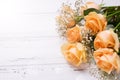 Fresh peach color roses flowers on white wooden background in ra Royalty Free Stock Photo