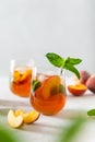 Fresh Peach iced tea. Iced tea with peach slices, mint and ice cubes on a white background. Close up. Homemade refreshing summer Royalty Free Stock Photo