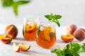 Fresh Peach iced tea. Iced tea with peach slices, mint and ice cubes on a white background. Close up. Homemade refreshing summer Royalty Free Stock Photo