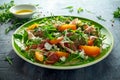 Fresh Peach salad with Parma ham, feta cheese and vegetables in a green plate. healthy food Royalty Free Stock Photo