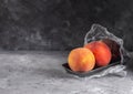 Fresh peaches in a plastic container with cling film on a dark background Royalty Free Stock Photo