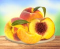 Fresh peaches on plate on table over nature Royalty Free Stock Photo