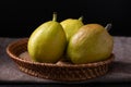 Fresh pear fruit in basket on fabric with black background Royalty Free Stock Photo