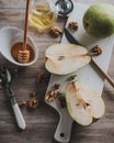 Pears, honey in a jar and nuts on a wooden table