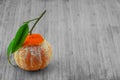 A fresh peeled mandarin with green leafs