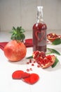 Fresh peeled pomegranates with ruby red beans and two hearts bottle with heart on wooden table background, selective focus, rustic