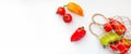 Fresh peppers in string bag on white background. Eco mesh with colorful vegetables. Banner with copy space, top view, flat lay.