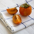Fresh persimmon over white wooden background, side view. Close-up Royalty Free Stock Photo