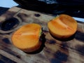 fresh persimmons split in half on a cutting board in the kitchen Royalty Free Stock Photo
