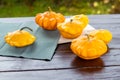 Yellow and orange summer squash, small pumpkins on a wooden table outdoors, autumn harvest, thanksgiving and farm food concept