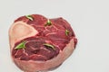 Fresh piece of meat large beef steak on the bone ossobuco with rosemary sprig.