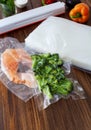 Fresh pieces of broccoli in a vacuum bag and a piece of red fish
