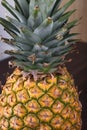 Fresh Pineapple being seen from a the top on a brown wooden table.