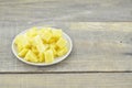 Fresh pineapple cut cubes in white plate on wooden table Royalty Free Stock Photo