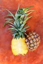 Fresh pineapple cut in half on orange rustic table Royalty Free Stock Photo
