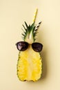 Fresh pineapple cut in two part, notebook or sketchbook and sunglasses on yellow background. Summer concept. Creative flat lay Royalty Free Stock Photo