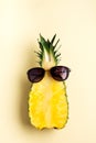 Fresh pineapple cut in two part, notebook or sketchbook and sunglasses on yellow background. Summer concept. Creative flat lay Royalty Free Stock Photo